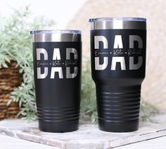 two black and silver tumblers with the words dad and son in white on them