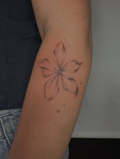 a woman's arm with a flower tattoo on the left side of her arm