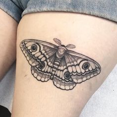 a small moth tattoo on the thigh, with an insect sitting on it's back