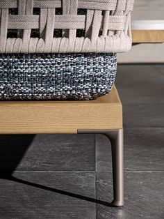 a basket sitting on top of a wooden table next to a metal leg rest and chair