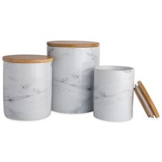 three white marble containers with wooden lids and chopsticks next to eachother