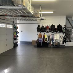 an empty garage with lots of luggage and backpacks hanging on the wall above it