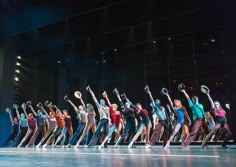 a group of people standing on top of a stage with their arms in the air