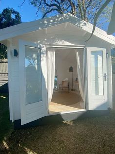 a small white shed with its doors open