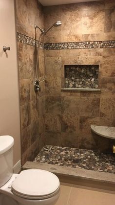 a walk in shower sitting next to a toilet under a window on top of a tiled floor