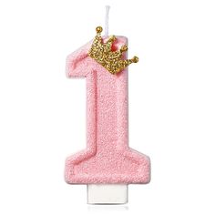 a pink number one candle with a crown on top