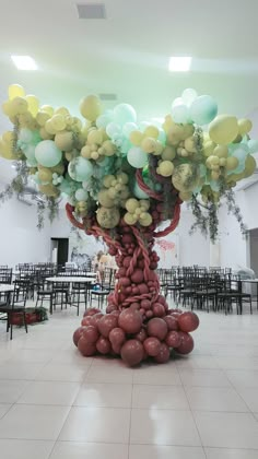 a large group of balloons in the shape of a tree on top of a tiled floor