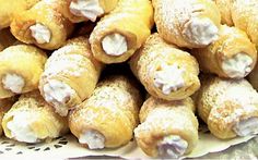 a pile of powdered donuts sitting on top of a doily covered table