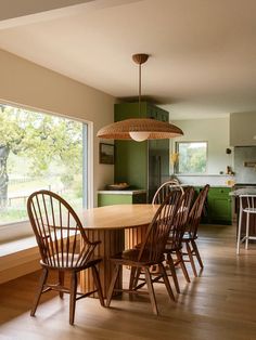 a dining room table and chairs in front of a window