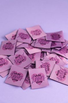 pink stickers with the words happy new year written on them are scattered across a purple background