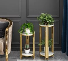 two gold side tables with plants on them