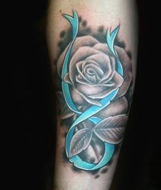 a black and grey rose with blue ribbon on the arm, done by tattoo artist person