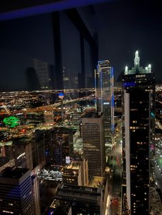 the city lights shine brightly at night in this view from an observation point on top of a skyscraper