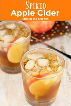 two glasses filled with apple cider on top of a table