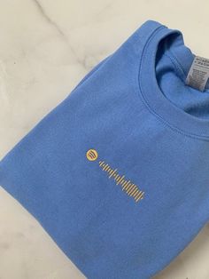 a blue t - shirt with the word champion on it sitting on a marble surface