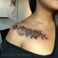 a woman's chest with roses on it and leaves around the top of her neck