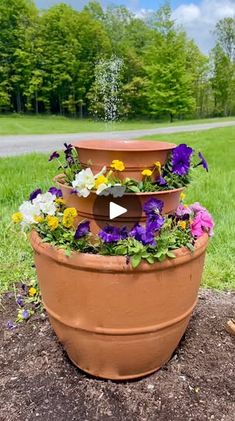 three flower pots are stacked on top of each other in the middle of a field