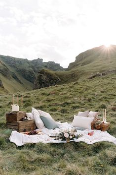 an outdoor picnic setting on the side of a mountain with flowers and candles in it