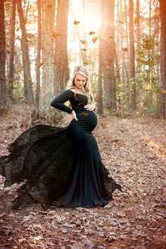 a woman in a black dress is posing for the camera with her hands on her hips