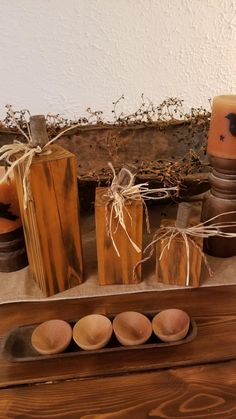 an assortment of wooden items displayed on a table with candles and other things in the background