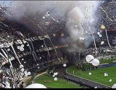 a stadium filled with lots of white balloons and confetti flying in the air