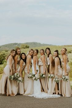 a group of women standing next to each other in front of a lush green field