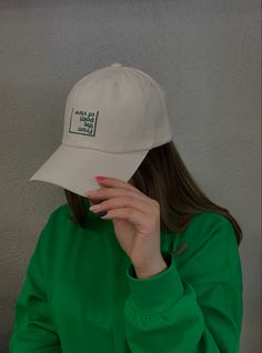 a woman wearing a green shirt and white hat