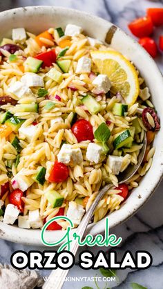 a white bowl filled with pasta salad and topped with feta cheese, cucumbers, tomatoes, olives