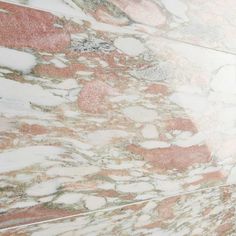 a bathroom with pink and white marble on the walls