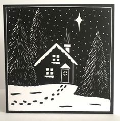 a black and white christmas card with a house in the snow at night, surrounded by trees