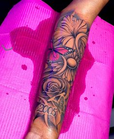 a woman's arm with flowers on it and a butterfly in the middle of her arm