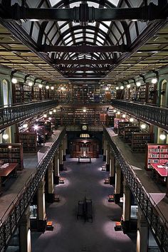 an iphone photo of a library with lots of books on the shelves and tables in it