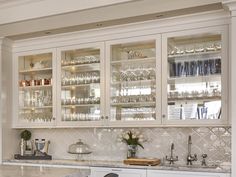 a kitchen with white cabinets and marble counter tops