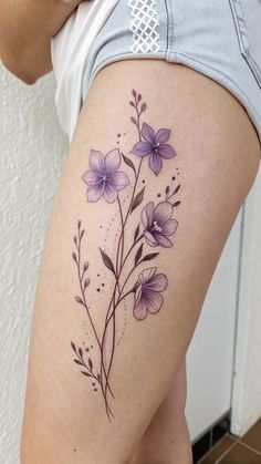 a woman's thigh with purple flowers on it