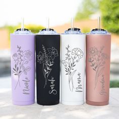 four different colored stainless steel tumblers with flowers on them