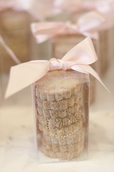 a close up of a small cake in a glass container with a bow on it