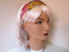 a mannequin head wearing a white wig with pink hair