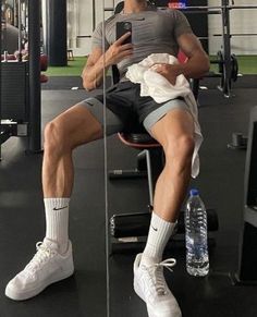 a man sitting in a gym chair using his cell phone