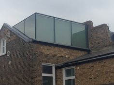 a brick building with two windows and a skylight on the top of it's roof