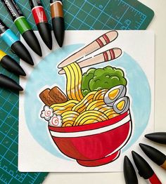 some crayons and markers are next to a drawing of a bowl of noodles