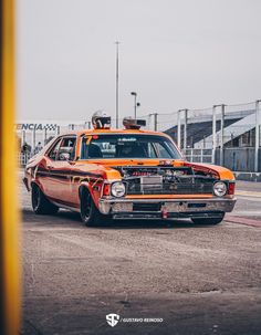 an orange and black car is driving down the street