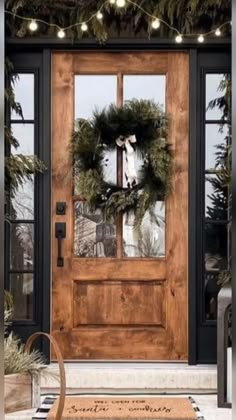 a front door decorated with christmas wreaths and lights