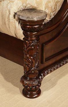 an ornate wooden bed frame with marble top