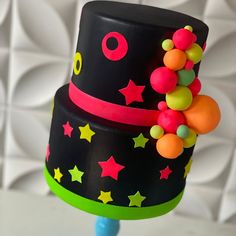 a three tiered black cake decorated with stars and beads