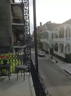 an empty street with cars parked on the side and buildings in the backround