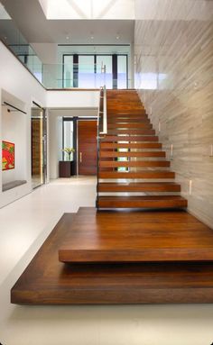 the stairs are made of wood and have glass railings