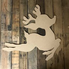 a wooden cutout of a deer leaping on wood planks, with the shape of an antelope