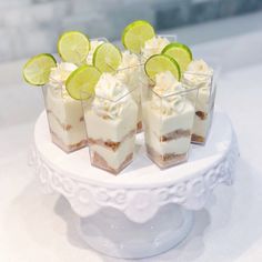 small desserts with lime slices and whipped cream on a white cake platter,