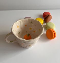 a cup filled with lots of different colored macaroons