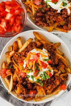 two white plates filled with chili cheese fries